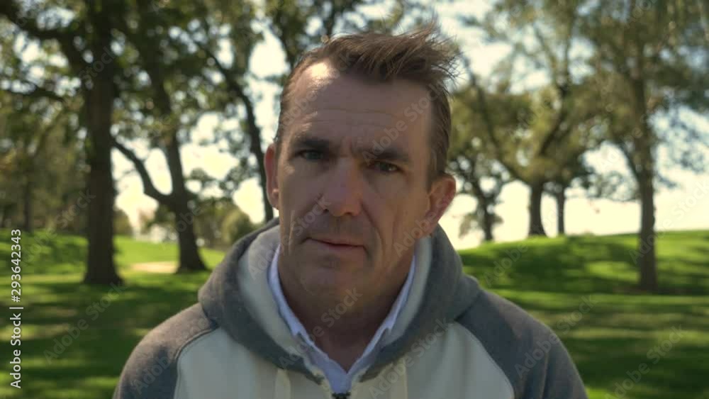 Portrait of a man in a park, sitting, looking angry, looking into the camera. Portrait of a man in a park, sitting, looking angry, looking into the camera.