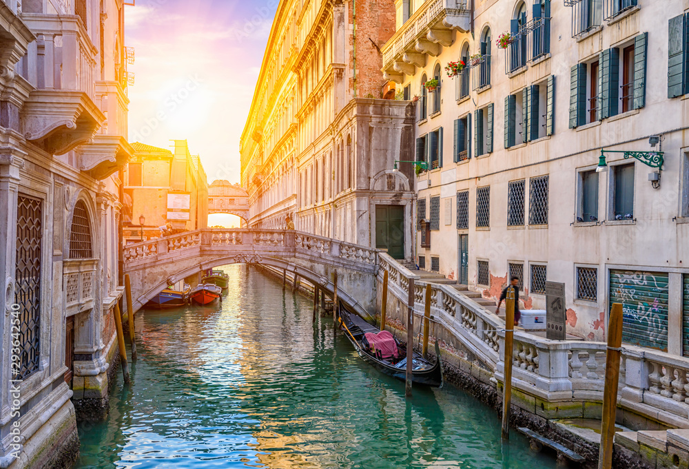 Fototapeta premium Narrow canal with gondola and bridge in Venice, Italy. Architecture and landmark of Venice. Cozy cityscape of Venice.