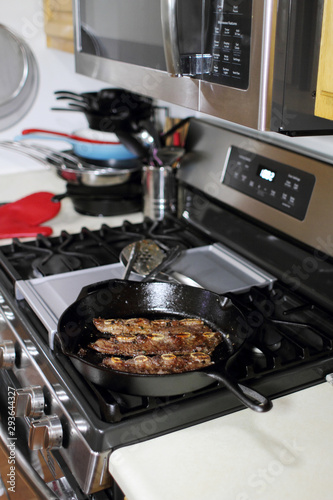 Korean style BBQ short ribs, known as Kalbi, on a cast iron skillet in a home kitchen.