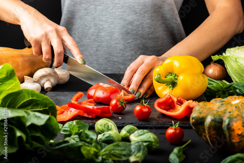 Woman's hands prepare vegetarian food, cut different vegetables. Healthy eating diet concept.