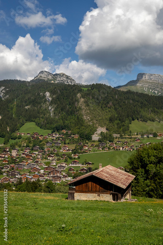 Mountain hut above a small village in the valley during summer in the background