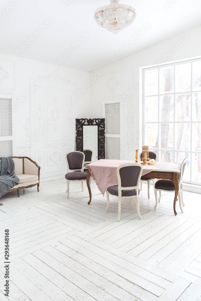 Fototapeta premium A spacious bright living room with a stylish modern design with elements of antique decor and beautiful chic furniture
