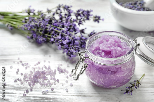 Natural sugar scrub and lavender flowers on white wooden table, space for text. Cosmetic product