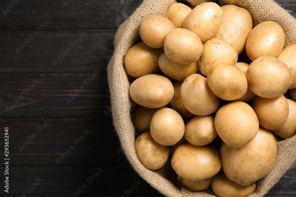 Raw fresh organic potatoes on black wooden background, top view. Space for text Raw fresh organic potatoes on black wooden background, top view. Space for text