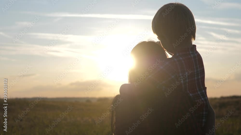 happy family mom and son lifestyle sunset slow motion video concept . back view Mother girl and a son boy playing on nature outdoors at the sunset time .Concept of friendly sunset family