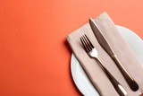 Elegant table setting on orange background, flat lay. Space for text
