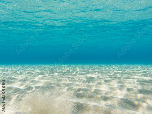 Clear water. Underwater background with sandy sea bottom.