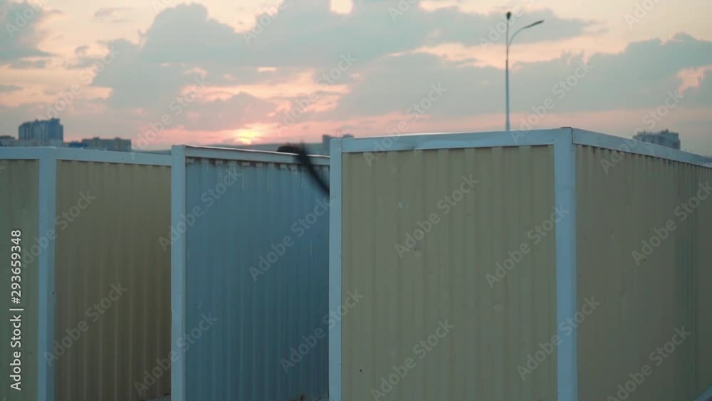 A young girl is in the locker room on the seashore. The girl changes clothes, throwing up a swimsuit, then leaves the locker room in a beautiful pink dress and leaves.