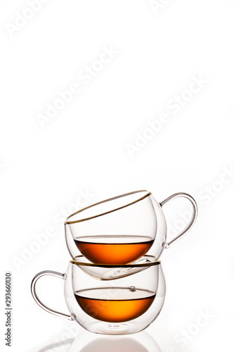 Glass cups with strong tea on white background, vertical frame