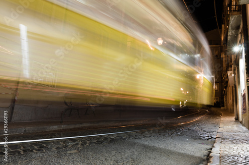 Moving yellow tram in old part of Lisbon at night. Blurred in motion, long exposure