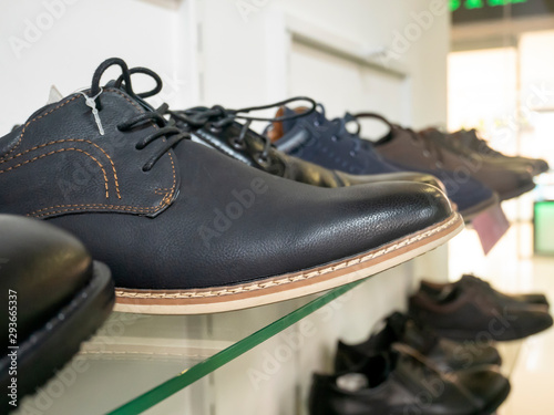Men's leather shoes on a glass shelf in the store, in the boutique.