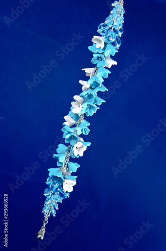 Beautiful handmade jewelry made of flowers on a blue background