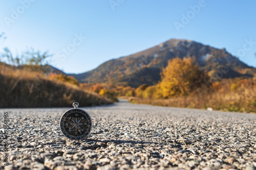 Compass on the road in the mountains, during sunset, in the fall.