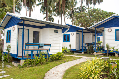 Blue and white holiday houses in green paradise landscape