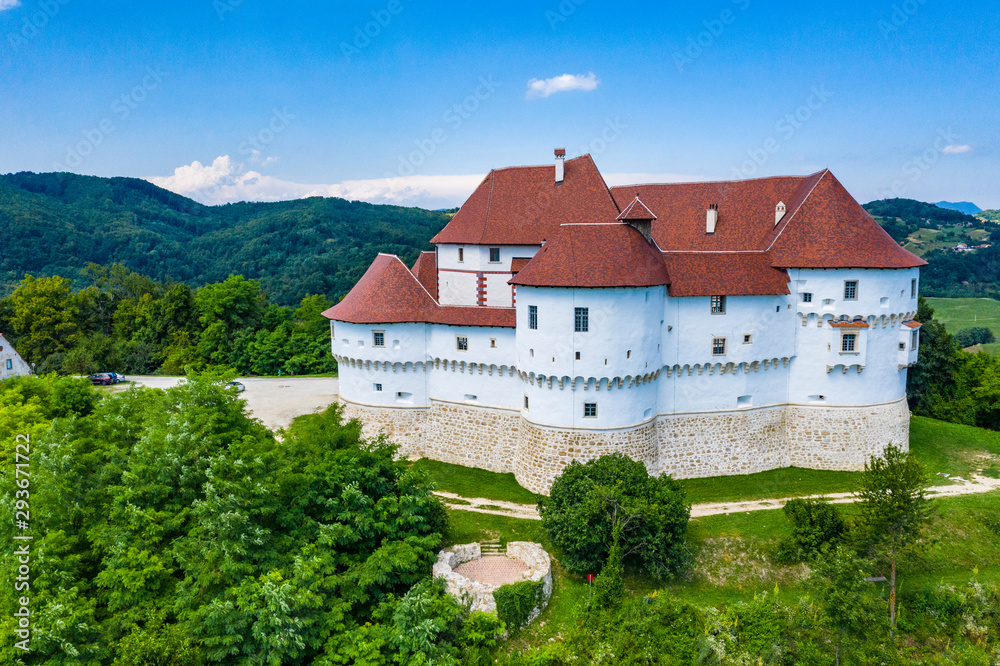 Aerial view of red roof of old medieval castle Veliki Tabor and green hills in Zagorje, northern Croatia on sunny summer day