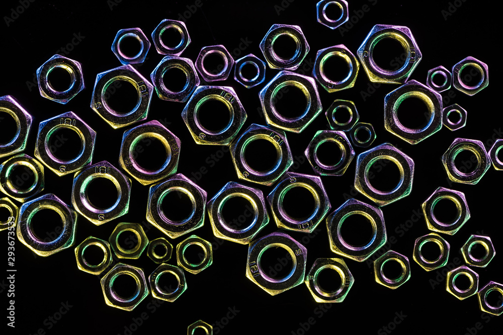 top view of scattered shiny metal nuts isolated on black top view of scattered shiny metal nuts isolated on black