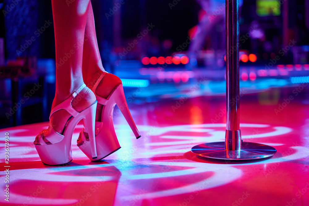 Young sexy woman pole dancing striptease with pylon in night club.  Beautiful naked stripper girl on stage. Beautiful female legs in  high-heeled shoes strips foto de Stock | Adobe Stock
