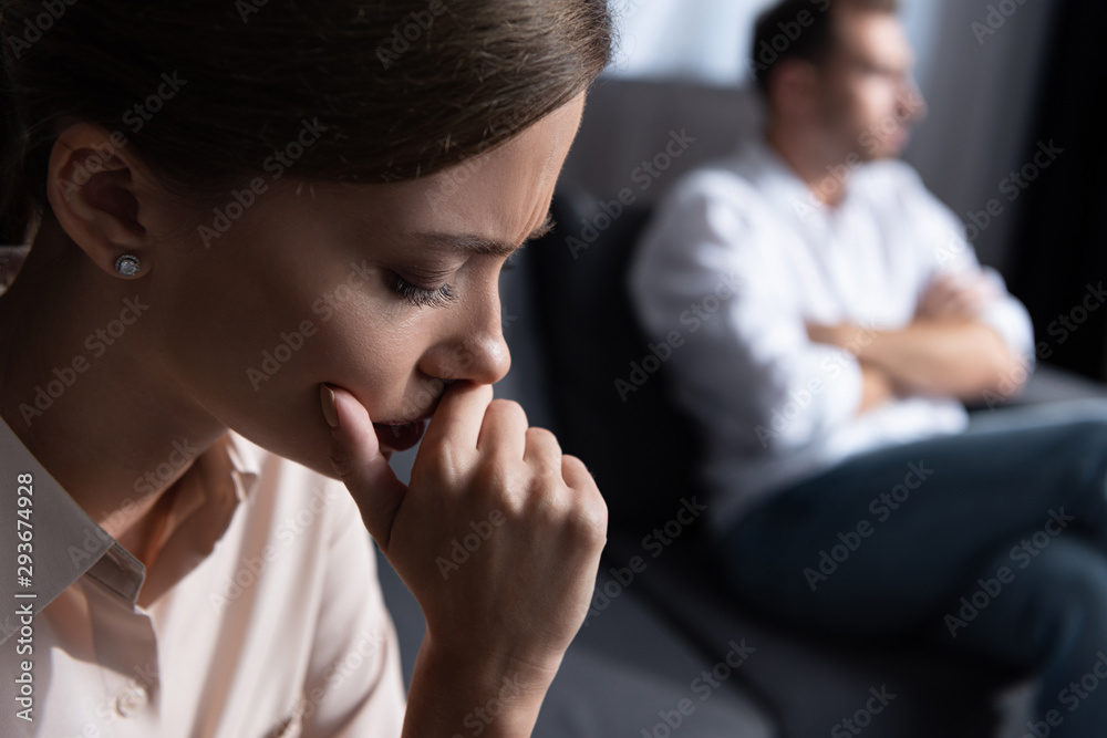upset pensive young woman and husband sitting on sofa upset pensive young woman and husband sitting on sofa