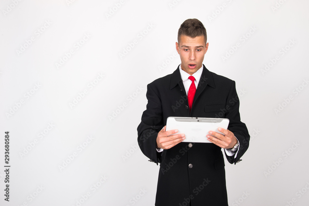 Handsome attractive smiling happy joyful young casual businessman male using tablet isolated on the white background, millennial modern working, gadget online data and information business concept Handsome attractive smiling happy joyful young casual businessman male using tablet isolated on the white background, millennial modern working, gadget online data and information business concept