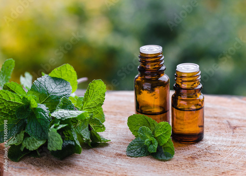 Natural Mint Essential Oil in a Glass Bottle with Fresh Mint Leaves