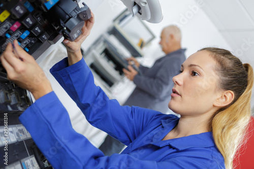 female apprentice fixing a printer