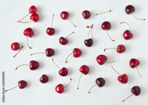 Murais de parede composition with red cherries scattered on white paper