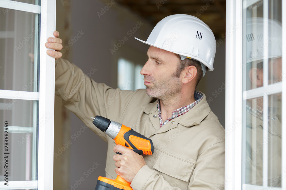 close up of a builder installing wooden blinds close up of a builder installing wooden blinds
