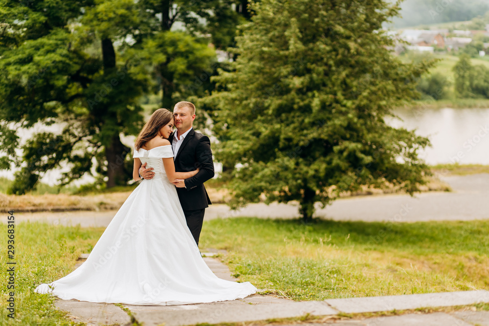 Pretty newlyweds posing together in the park Pretty newlyweds posing together in the park