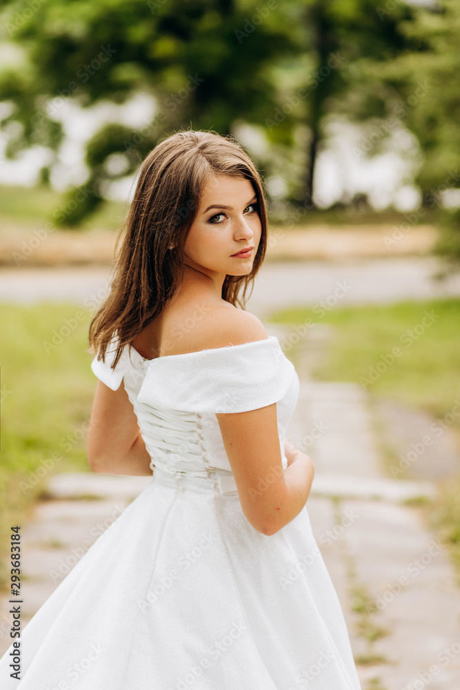 Charming bride in white dress posing in the park Charming bride in white dress posing in the park