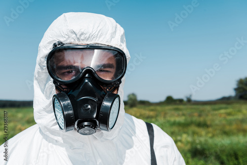 exterminator in uniform and protective mask looking at camera against sky © LIGHTFIELD STUDIOS