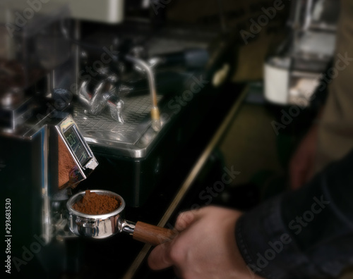 Macro shot grinding coffee on professional grinder machine