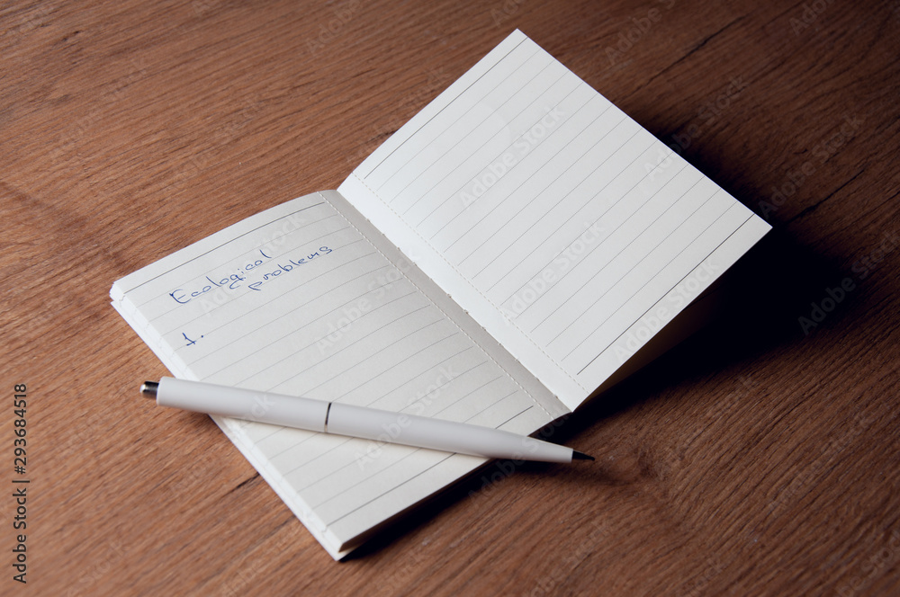 Writing notes about the environment in a notebook. Pocket Notebook. Writing notes about the environment in a notebook. Pocket Notebook.