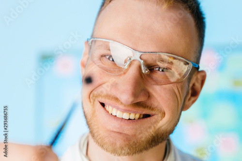 Man in glasses looks at microchip
