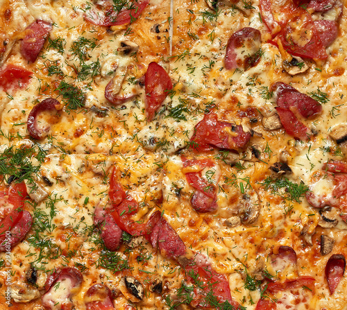 baked round pizza with smoked sausages, mushrooms, tomatoes, cheese and dill