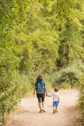 Quadro em tela A woman and a child hiking, walking along a dirt path.