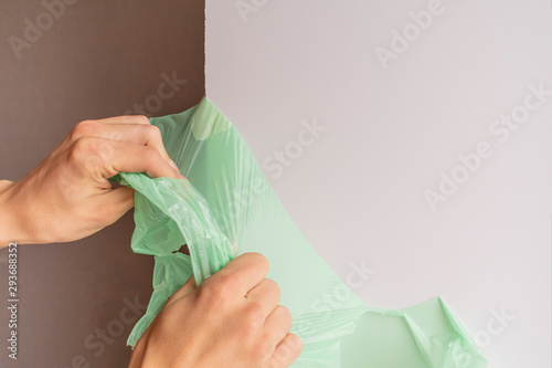 Fotografie Worker removes the protective film from the plastic slope