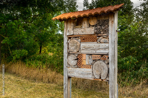 Großes und schönes Insektenhotel in der Flur an einem Bach mit einem Ziegeldach als Schutz gegen Regen photo