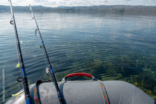 boat fishing trolling in deep blue sea with rods and reels