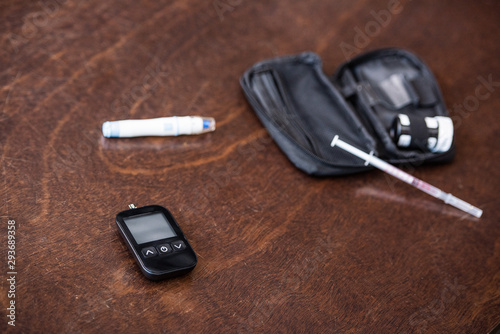 selective focus of glucose monitor near blood lancer on table