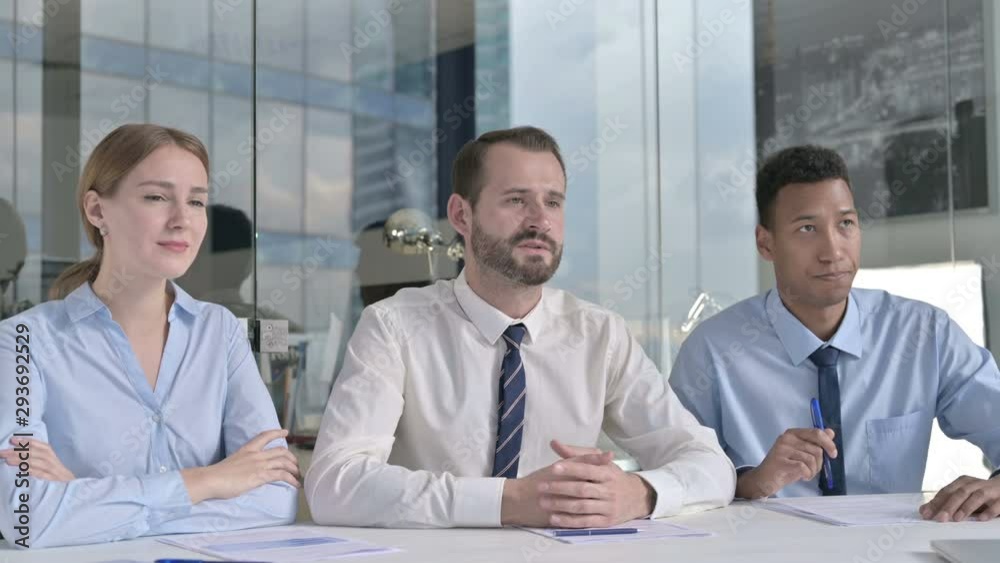 Middle Aged Businessman giving Presentation with Assistants on Office Table Middle Aged Businessman giving Presentation with Assistants on Office Table