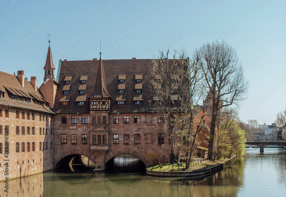 Heilig Geist Spital (Hospice of the Holy Spirit) facade, view of the Pegnitz River in Nuremberg from Fleisch Bridge, Bavaria, Germany.