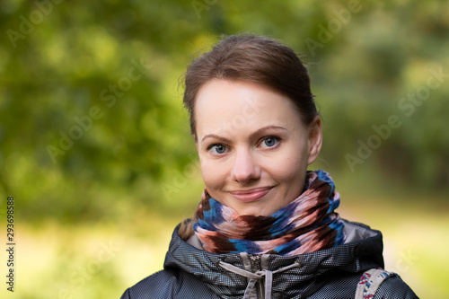 Portrait of happy girl over foliage background at autumn day