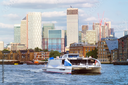 Photography Catamaran on the river Thames in London with Canary Wharf on the