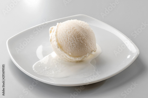 ice cream scoop on white plate close-up  against neutral background
