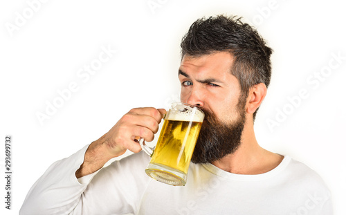 Beer pub. Beer time. Alcohol, harmful habits. Oktoberfest. Stylish handsome man drinking beer of glass on party. Smiling bearded hipster drinking craft beer from mug. Brewing. Stylish guy at cafe pub.
