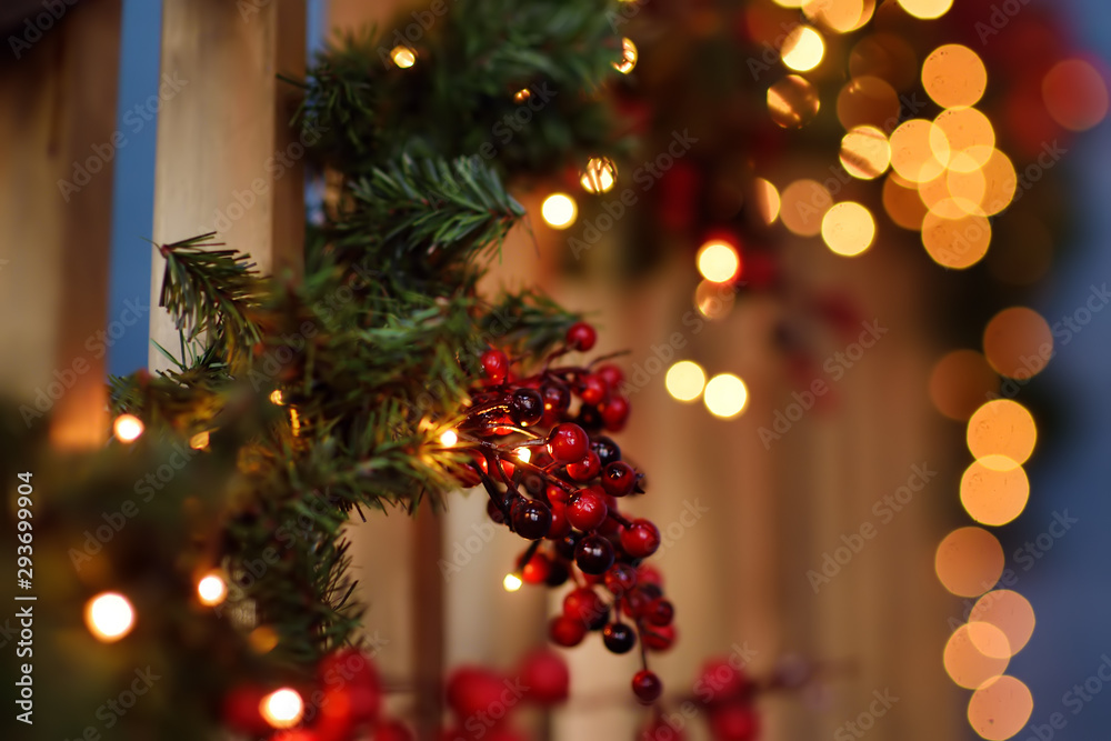 Part of christmas decorating house interior. Wreath with fir and red berries. Illuminating garland. Part of christmas decorating house interior. Wreath with fir and red berries. Illuminating garland.