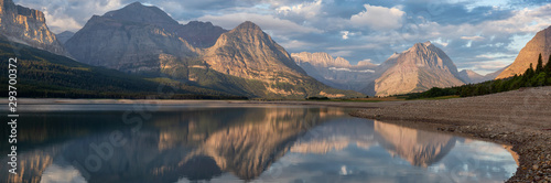 Beautiful Panoramic View of American Rocky Mountain Landscape during a Cloudy Morning Sunrise. Taken in Glacier National Park, Montana, United States.