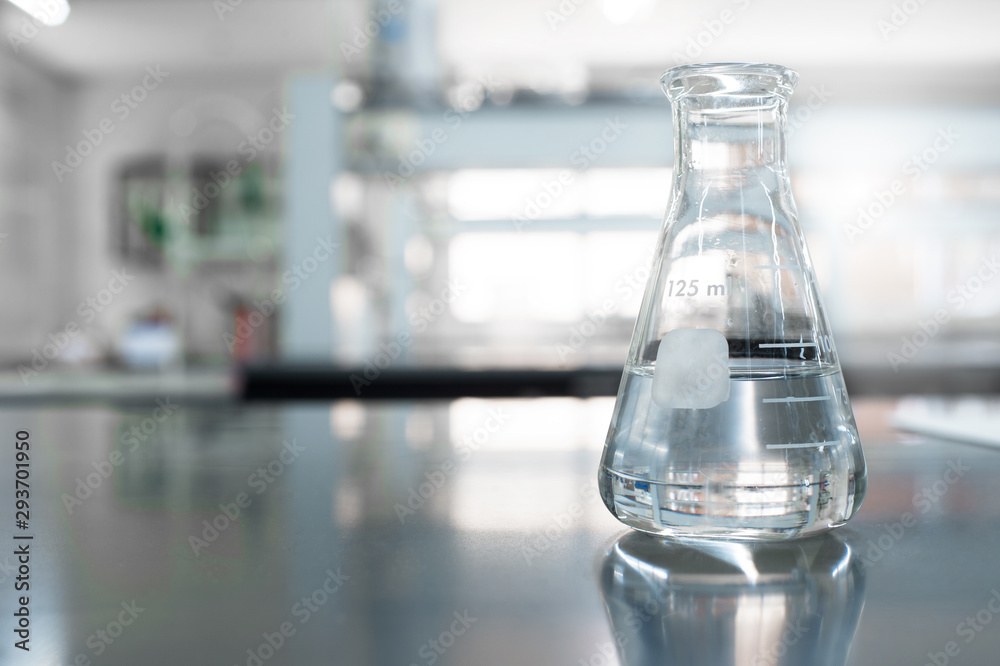 single glass flask with water in chemistry education laboratory background single glass flask with water in chemistry education laboratory background