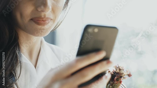 close-up of woman smile with arm holding phone and arm holding fok with salad photo