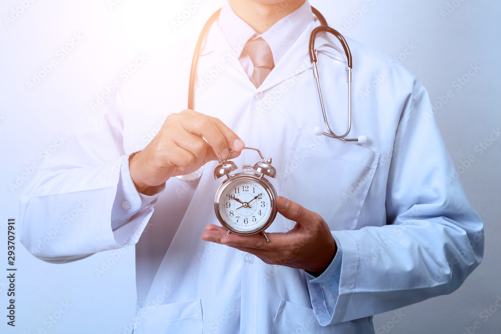 Doctor holding a clock,  Concept for timing, medical and healthcare - obrazy, fototapety, plakaty 
